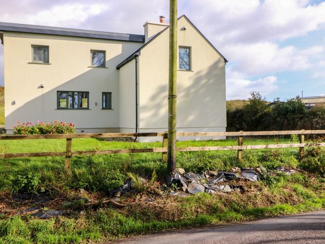 A house exterior with a fence and grass at Knocknanuss in Ballinascarty, County Cork