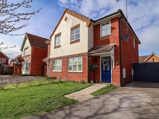 A house with a blue door and windows at The Beach Escape in Prestatyn