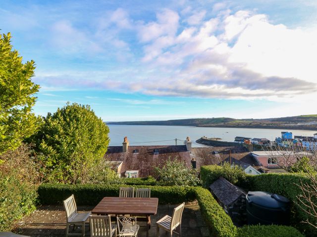 A view of the ocean with table and chairs at Zenobia in New Quay
