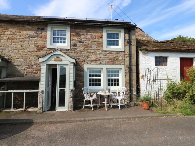 A cottage exterior with chairs and a table at Ashtree Cottage