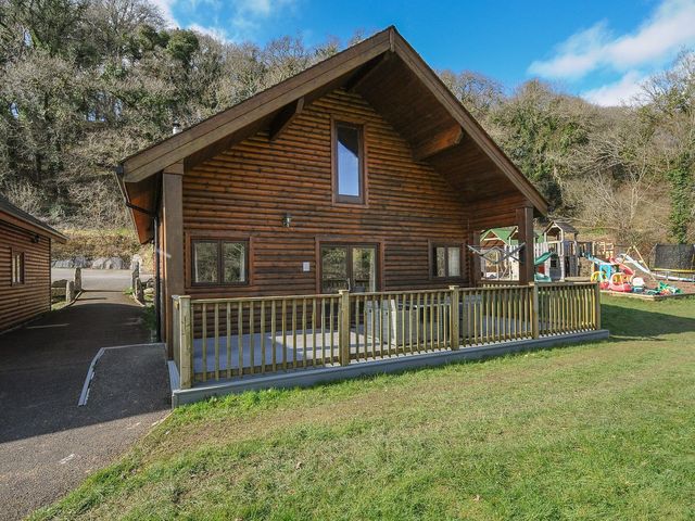 A wooden house with a deck and playground at Pencarrow St Breward