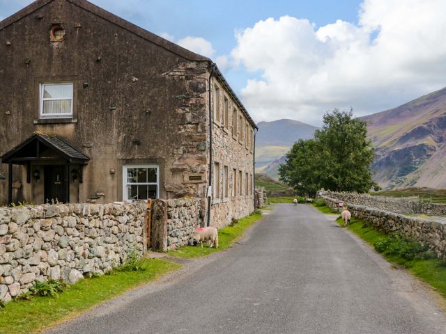 A stone house alongside a road with sheep at Buckbarrow in Seascale