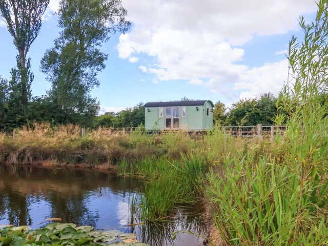 A shepherd hut beside a body of water at Shepherds hut in 