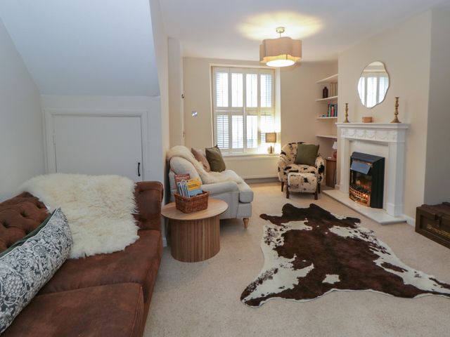 A living room with a sofa and fireplace at Cariad Cottage in Hereford
