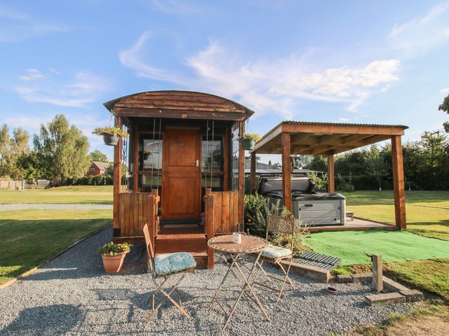 An outdoor area with a shepherd hut and hot tub at Sharon's Shepherd Hut Oswestry