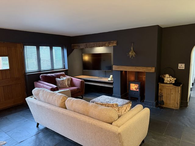 A living room with a sofa and television at New House Barn in Ashbourne