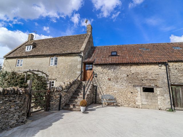 An outdoor view of a house with stairs and a fence at The Old Dairy in Acton Turville near Nettleton