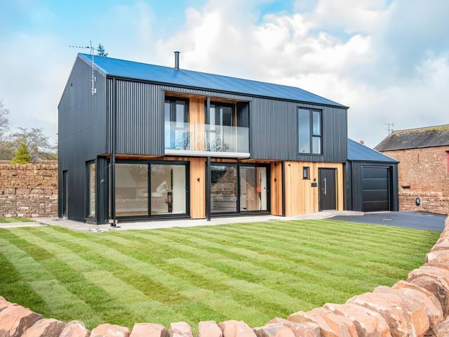 A house with large windows and grass area at the property in 