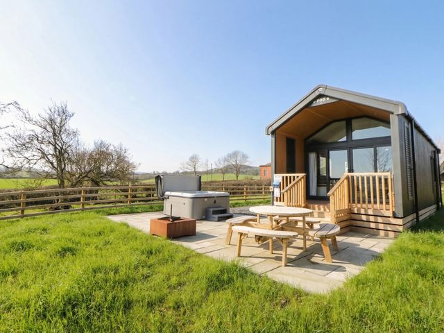 An outdoor area with a hot tub and seating at Daverneithon 1 Near Llandrindod Wells