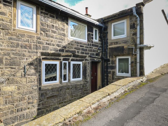 An exterior view of a stone building with windows and a door at 11 Hollin Well Cottage Sowerby Bridge