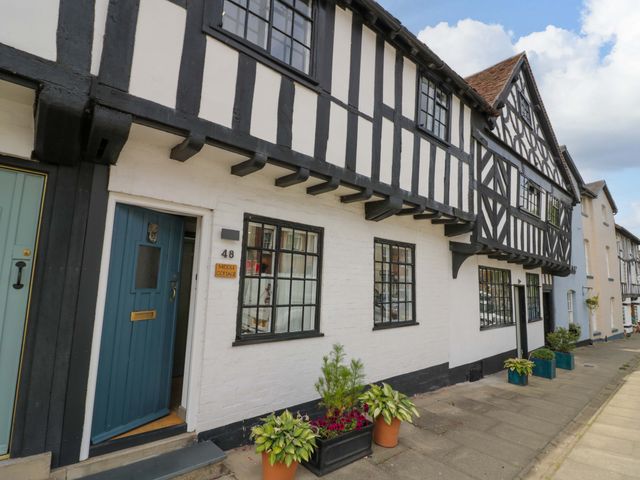 The exterior of a house with timber framing and a blue door at Middle Cottage in Ludlow