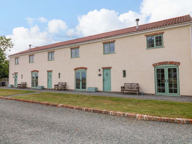 An exterior view of a building with benches and grass at Mylo's Cottage Langrick near Boston