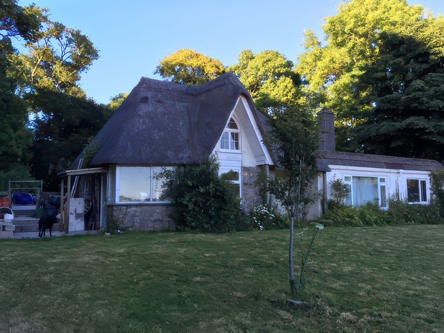 A house with a thatched roof and garden at Tapps Lodge Brixton near Yealmpton, South Devon