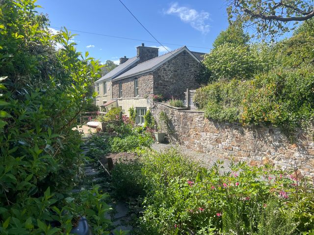 A house and garden with flowers at Penally Mews in St Dogmaels