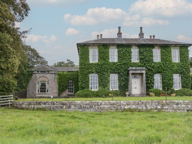 A house covered in ivy with windows and a door at The Old Kitchen in Cartmel