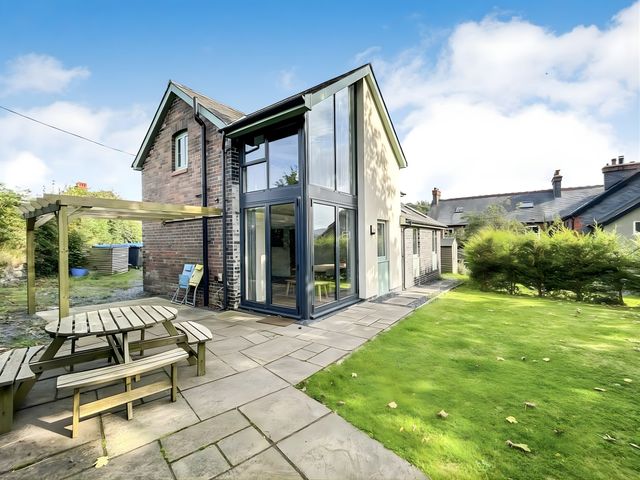 A house with a garden and patio area at Hen Stablau in Corwen