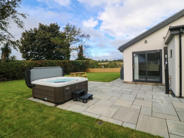 A hot tub on the patio in the garden at Angorfa in Pentraeth
