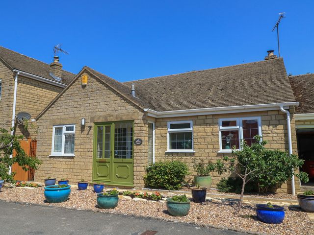 A house with a green front door and garden at Evergreen in Broadway