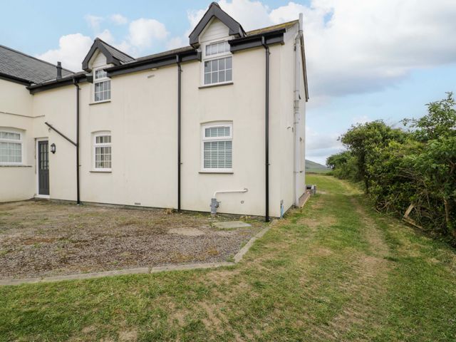 An exterior view of a house with a pathway at Rosemary Cottage 2 in Tywyn