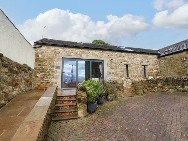 An outdoor area with a stone building and steps at The Warren Barn in Kirkby Malzeard