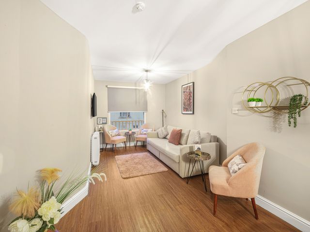 A living room with a sofa, coffee table, and television at Ravenswood Penthouse in Chester