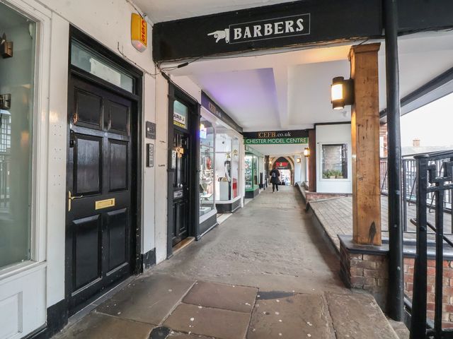 An outdoor walkway with shops and a barbers at Ravenswood Penthouse Chester