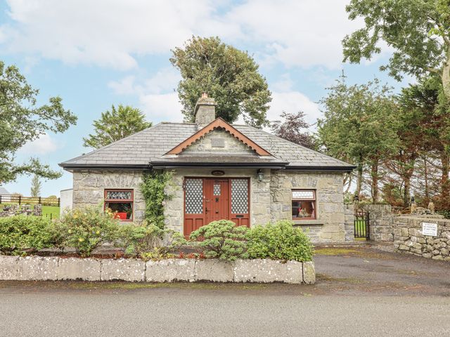 A stone house with a front door and windows at Coole Gate Lodge, Gort, County Galway