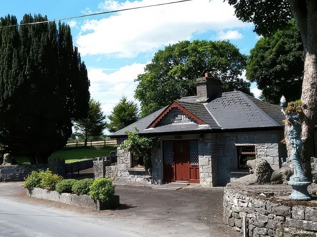 A building with stone walls and a red door at Coole Gate Lodge in Gort, County Galway