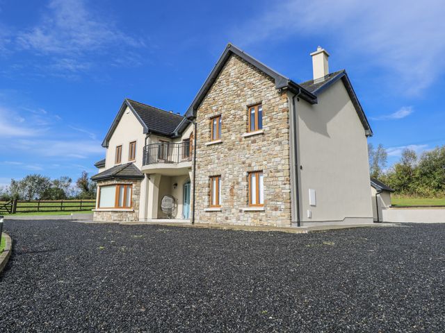 A house with a stone exterior and driveway at Woodlawn Retreat in Portanure near Lough Gowna