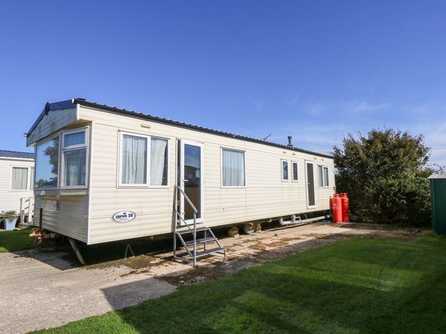 A static caravan with gas cylinders outside at Number 38 Chichester