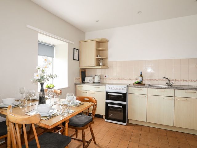A kitchen with a dining table set at Ceiriad - 9 Ty'n Don in Llanengan near Abersoch