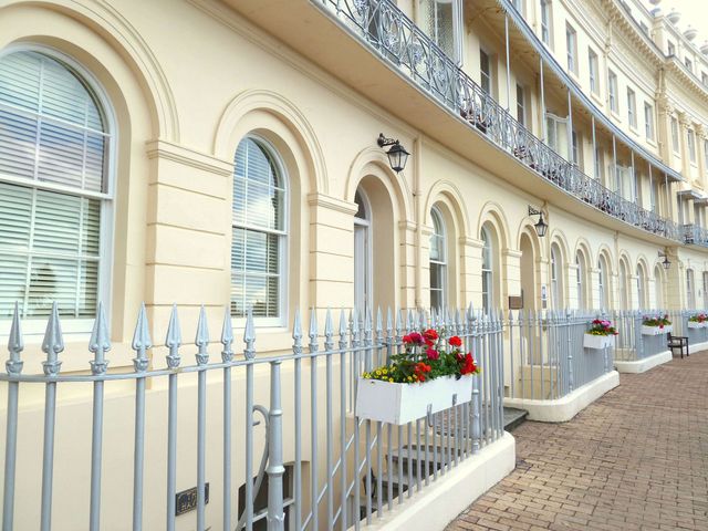 An exterior view of a residential building with decorative railings and planters at Meadfoot Bay Apartment at Hesketh Crescent, Torquay