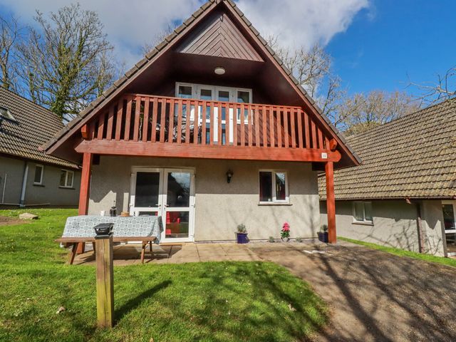 A house with a balcony and garden at Mayfly Lodge in St Tudy