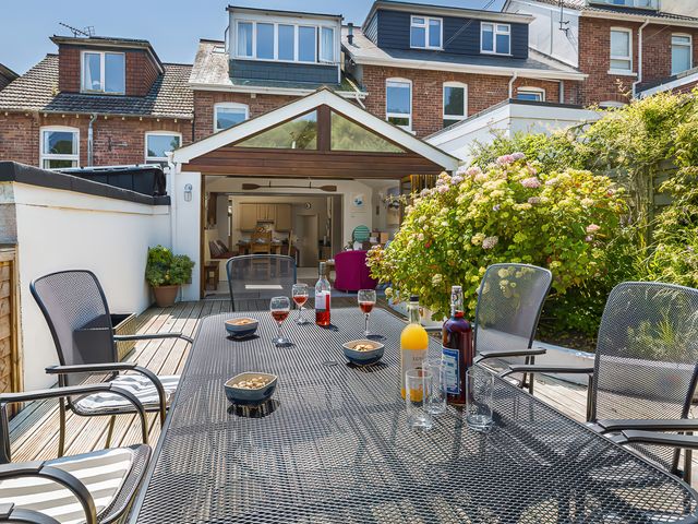 An outdoor seating area with a table and drinks at Shipwrights in Salcombe