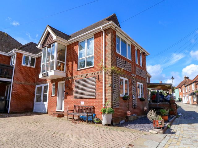 A two-story house with windows and a bench at Riverview in Hamble