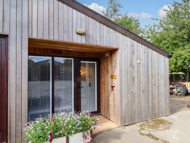 An entrance with a glass door and wooden facade at The Old Shippon