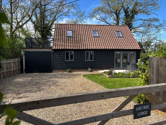 A house with a garden and gravel driveway at Ash Tree Lodge in Norwich