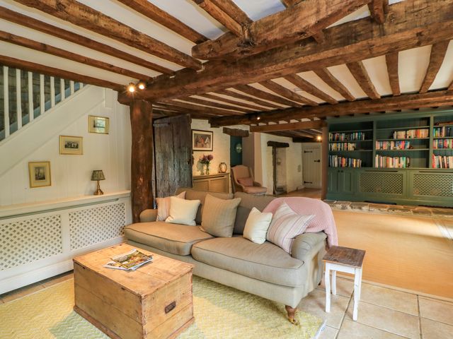 A living room with a sofa and bookshelf at The Farmhouse in Langport