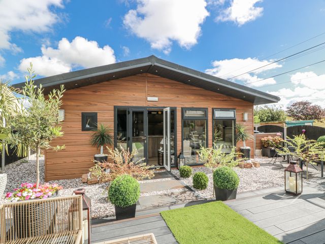 A house with plants and outdoor furniture at Cabin At The Brig Annan