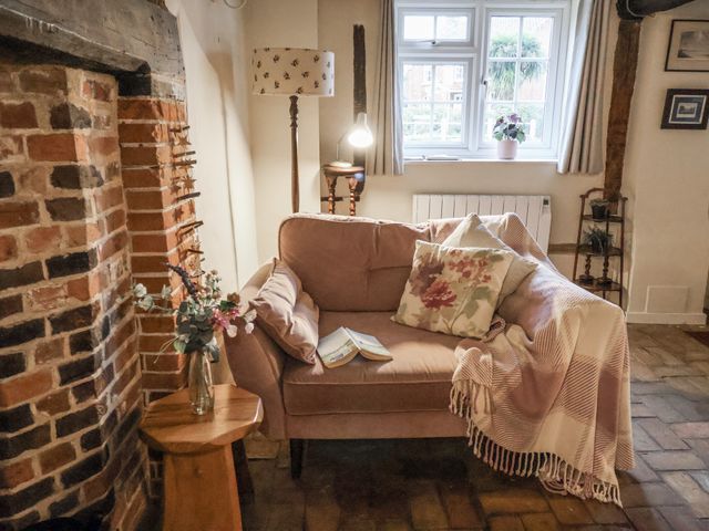 A living room with a sofa and fireplace at The Old Post Box in Halesworth