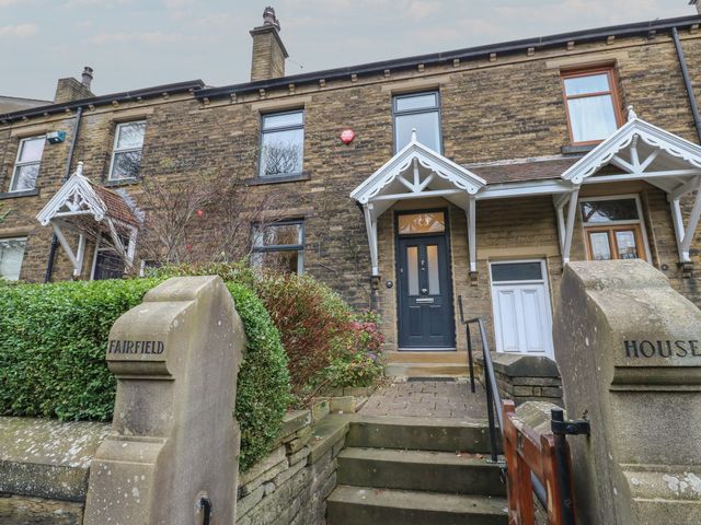 A terraced house with stairs and a bush at Fairfield House in Almondbury