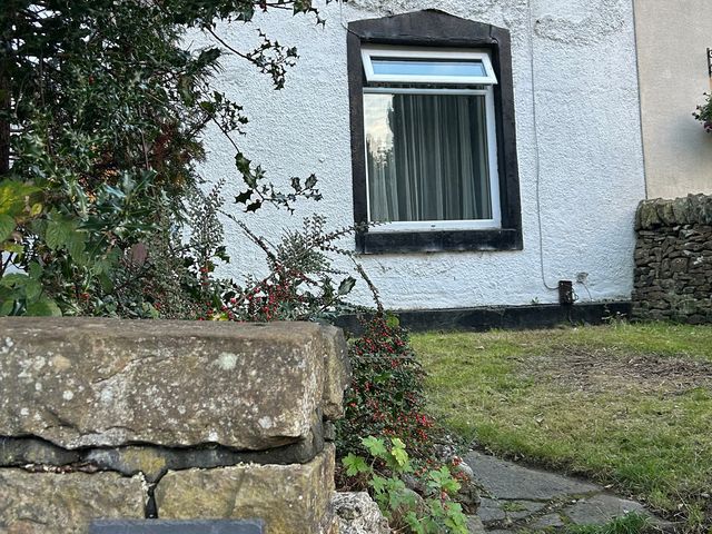 A house exterior with a window and garden at Mallison Cottage Ashton-Under-Lyne