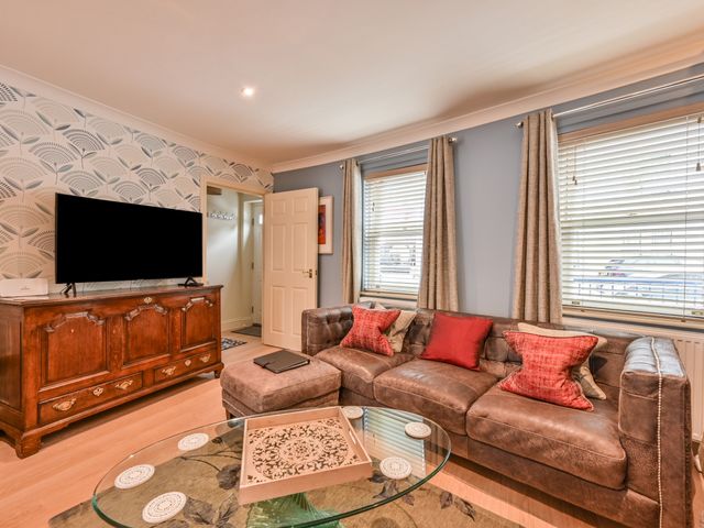 A living room with a sofa and television at Lisburne Place in Torquay