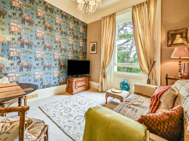 A living room with a television and seating area at Muntham Apartment 6 in Torquay