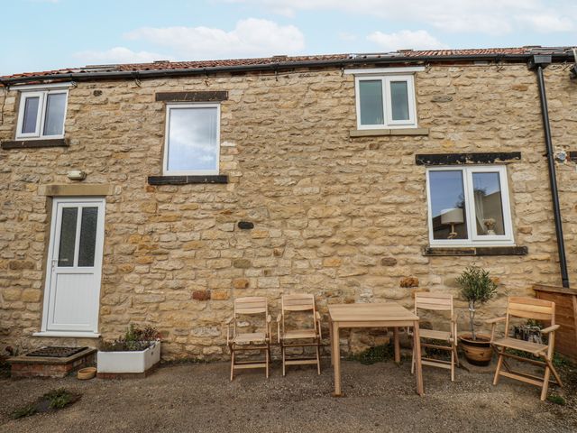 An outdoor seating area with a table and chairs at Starlight Cottage