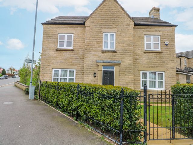 A house with a fence and hedges at The Winster in Marple, Stockport