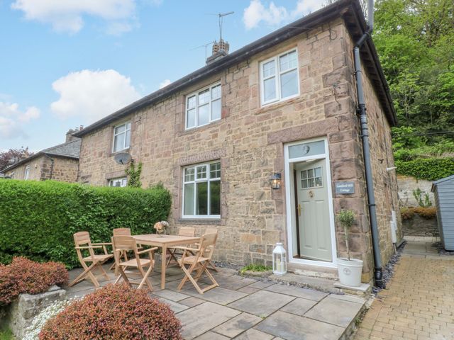 A cottage with a garden and seating area at Lumford Mill Cottage in Bakewell