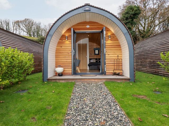 An entrance to a wooden pod structure with a gravel path at Barry in Polgooth