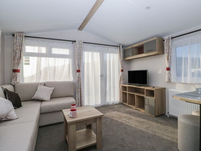 A living room with a sofa and television at Mobility Friendly Caravan in St Bees