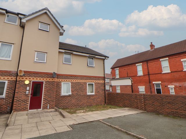 An exterior view of a building with windows and a door at Flat 12 Wallasey